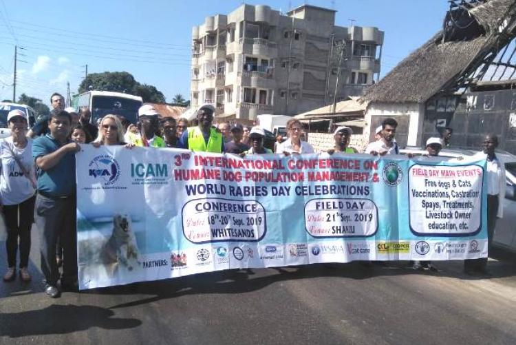 ICAM (2019) conference attender pose  for a photo with the conference banner 