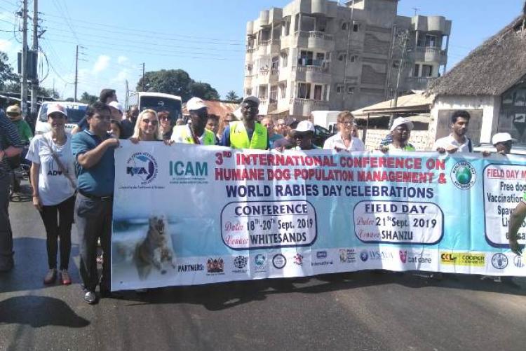 ICAM (2019) conference attender pose  for a photo with the conference banner  2